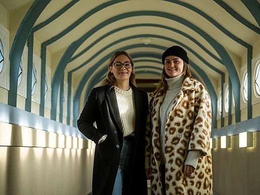 Zwei Studentinnen stehen im Görlitzer Hochschulgebäude in Winterkleidung.