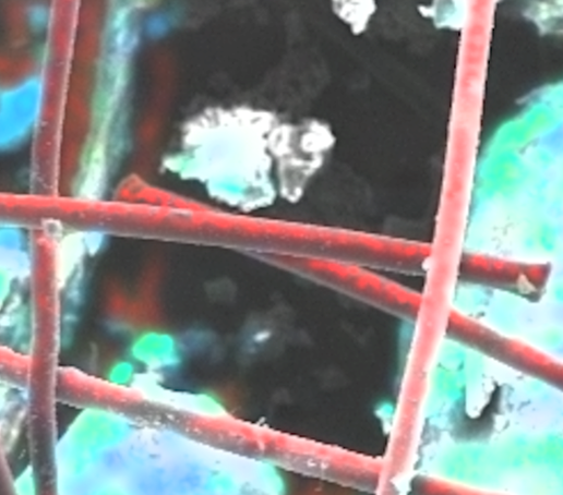 This image shows polypropylene fibers in a soil matrix in an SEM/EDX image. The plastic fibers appear red due to their high content of pure carbon and the absence of other elements.