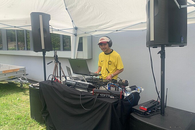 A DJ plays music from his DJ booth.
