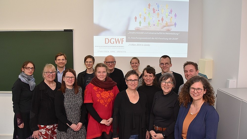 TRAWOS employees as a group in front of a beamer projection in a seminar room