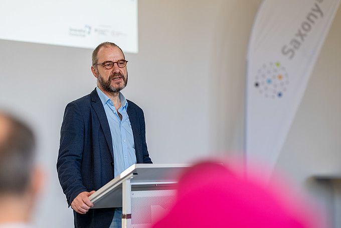 The Vice-Rector for Research, Prof. Raj Kollmorgen, stands at a lectern.