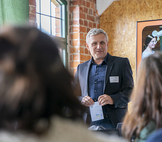 A conference participant speaks in front of the seated guests.