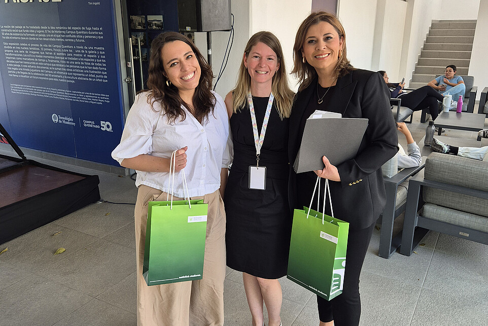 Two women are holding an HSZG gift bag, with Patricia Stange in the middle.