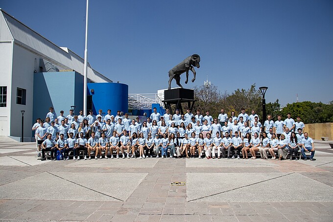 Group photo of the participants in the outdoor area in front of a statue.
