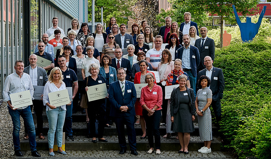 Foto: Marcel Schröder Eine Gruppe aus Hochschulmitgliedern und Kooperationspartnern aus dem Pflegebereich steht neben der Blue-Box am Campus Görlitz.
