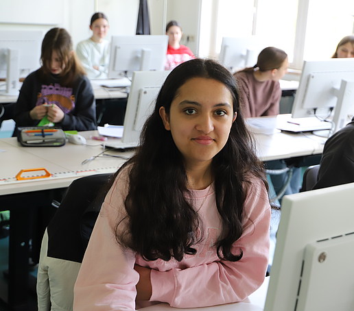 A schoolgirl with black hair sits at the computer in the CAD lab.