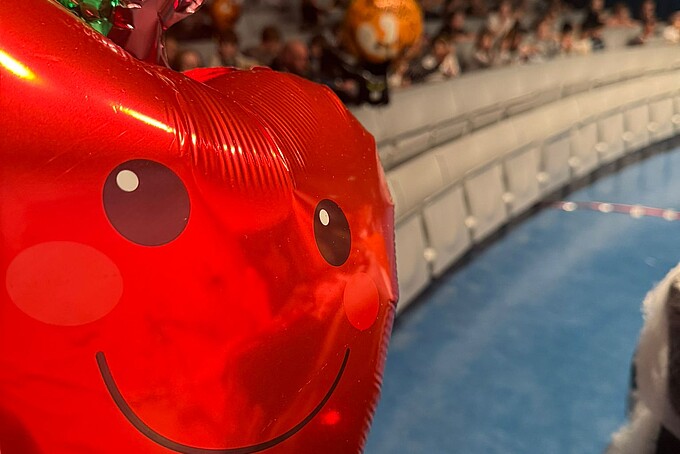 A red apple balloon flies in front of the stage.