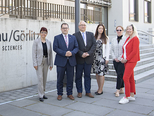 Representatives of HSZG and TU Liberec in front of the lettering of HSZG building one.