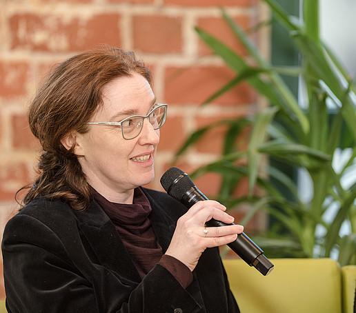 Lucie Koutková with microphone on the talk sofa