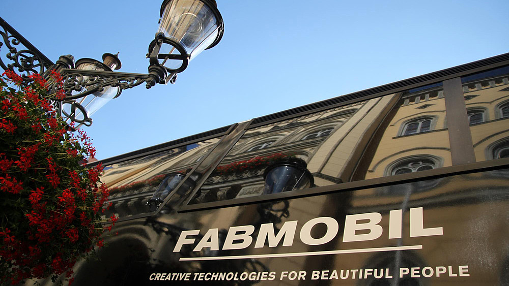 Close-up of a street lamp with the Fabmobil lettering in the background on the Zittau market square