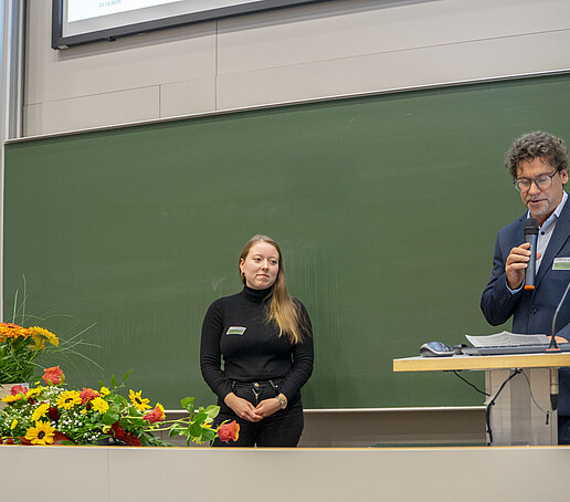 Prof. Zips holds a laudatory speech for the Al-Makhawi prizewinner, who stands smiling.