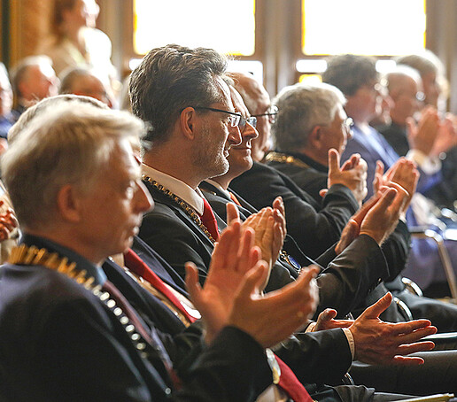 Principals sit in the audience and applaud.