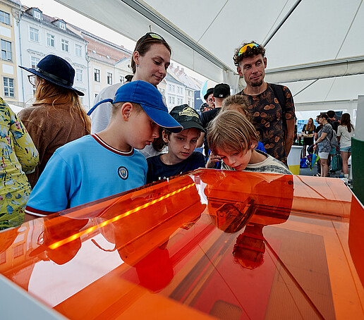 Children inform themselves at a stand with a flow system.