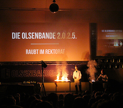 Two performers conduct a fire experiment.