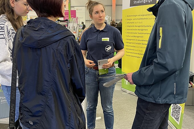 Eine HSZG-Mitarbeiterin berät Studieninteressierte am Stand.