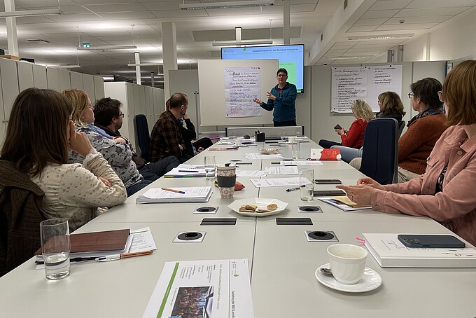 An employee explains something to the participants using a flipchart.