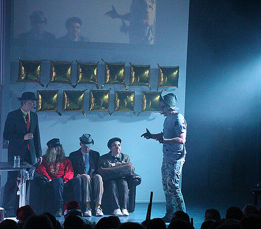 Performers talk on stage.