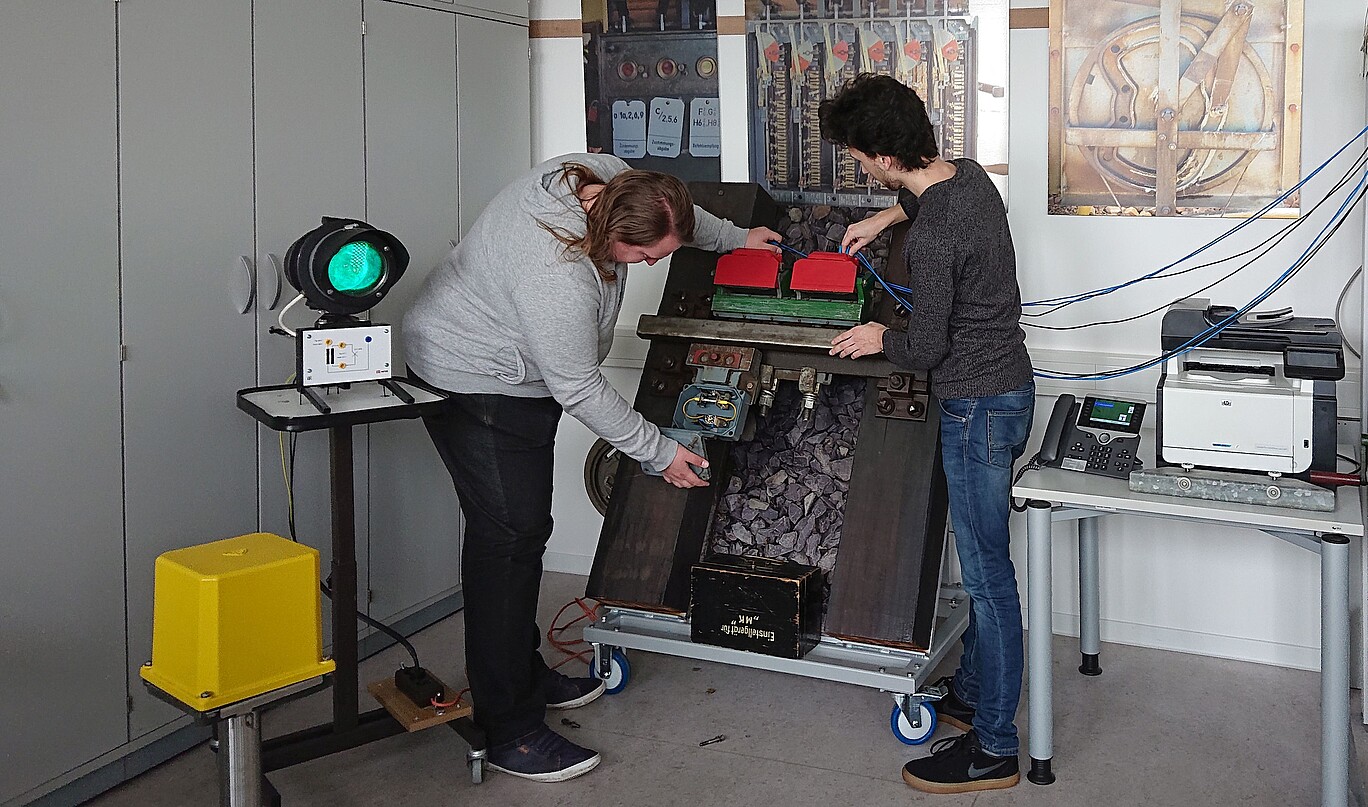 two people work on a technical test stand