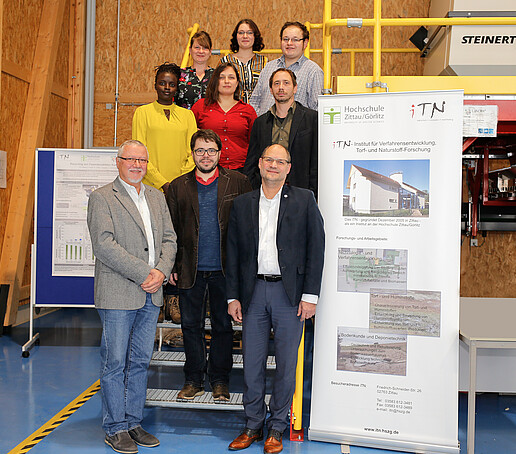 The junior researchers and the supervising professors stand on a staircase