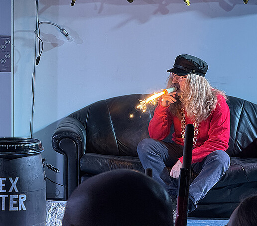 A performer lights a fire-spraying cigar.