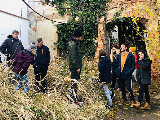 A group of students looks at the gap between buildings.