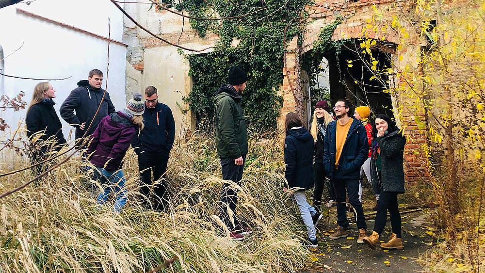 A group of students looks at the gap between buildings.