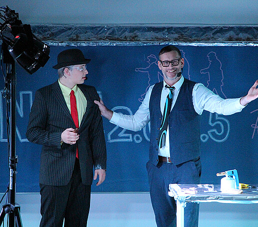 Two actors are talking on stage.