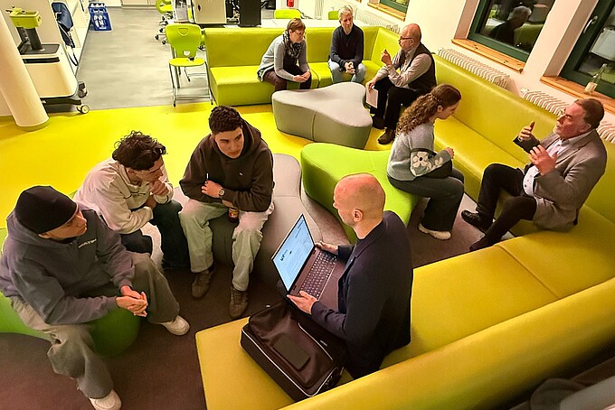 Students sit on sofas and talk to a counselor.