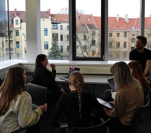 A group of workshop participants in conversation in the seminar room.