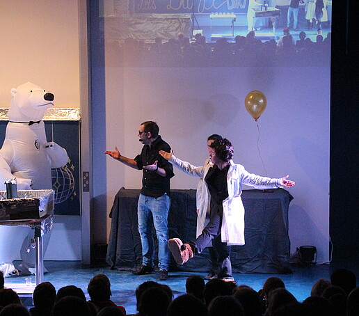 The polar bear and the presenters on stage.