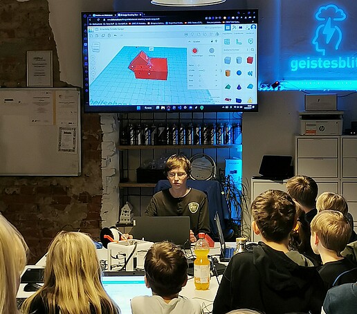 Alexander Sörgel shows how the children can print their own shopping cart chip on a monitor.