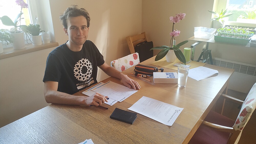 Male participant at dining table with note and pen