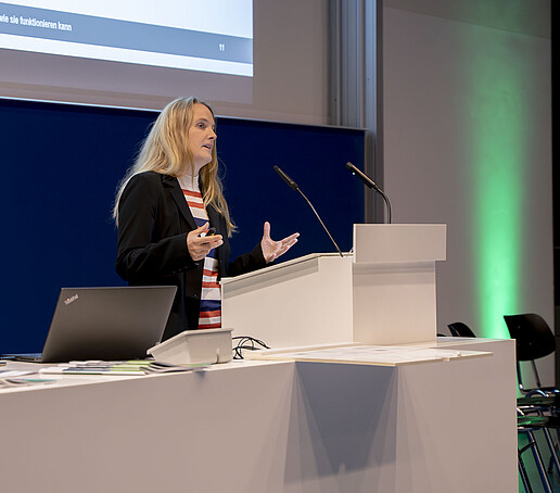 Stefanie Kast stands at a lectern and gives a lecture.