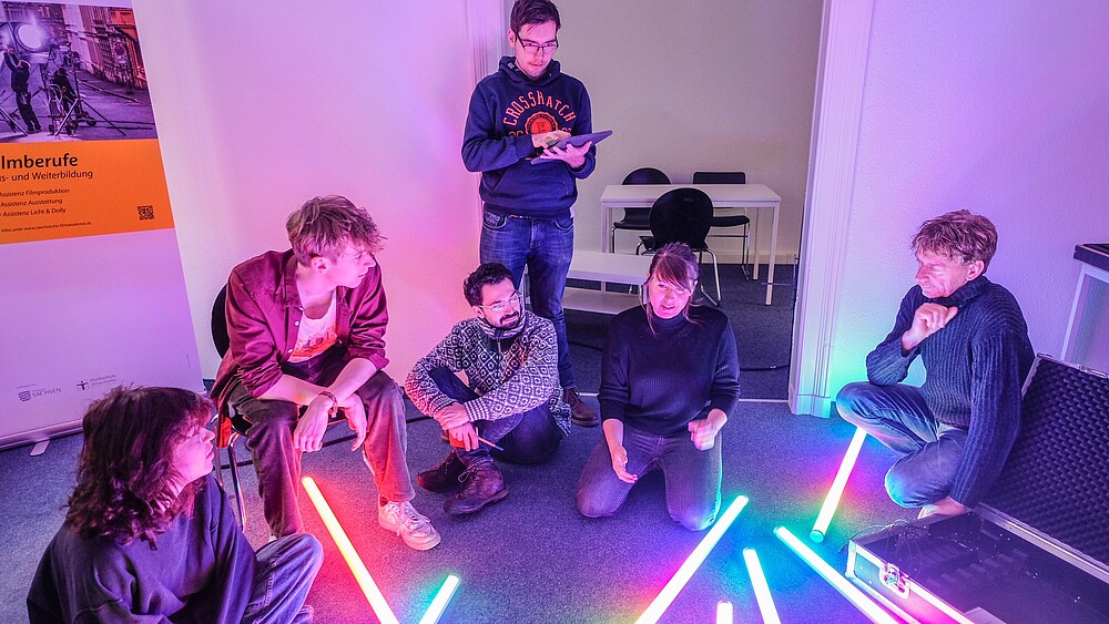 A group of course participants in the seminar room with fluorescent tubes on the floor.