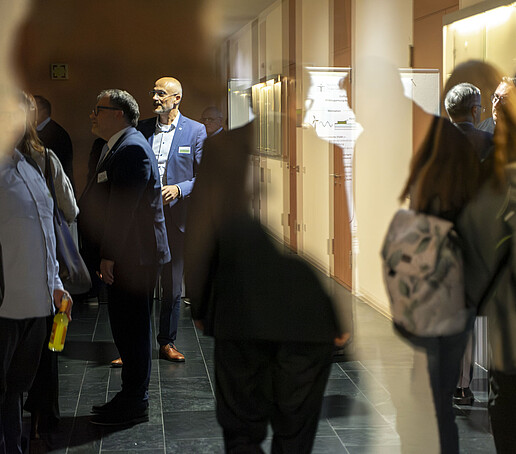 Guests walk along a dark corridor, which is illuminated along the walls, and look at exhibits.