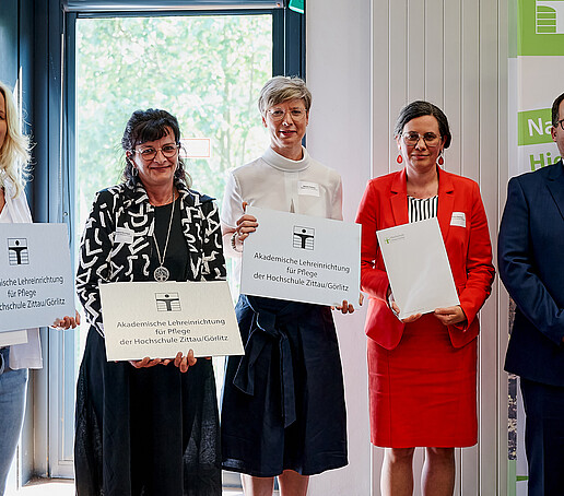 Rector with three cooperation partners in the care sector. They are holding their figurehead and certificate in their hands.