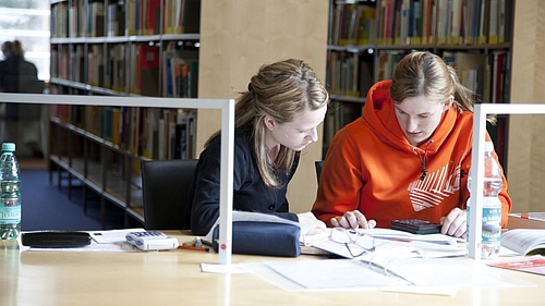 Zwei Studentinnen beim Lernen in der Bibliothek.