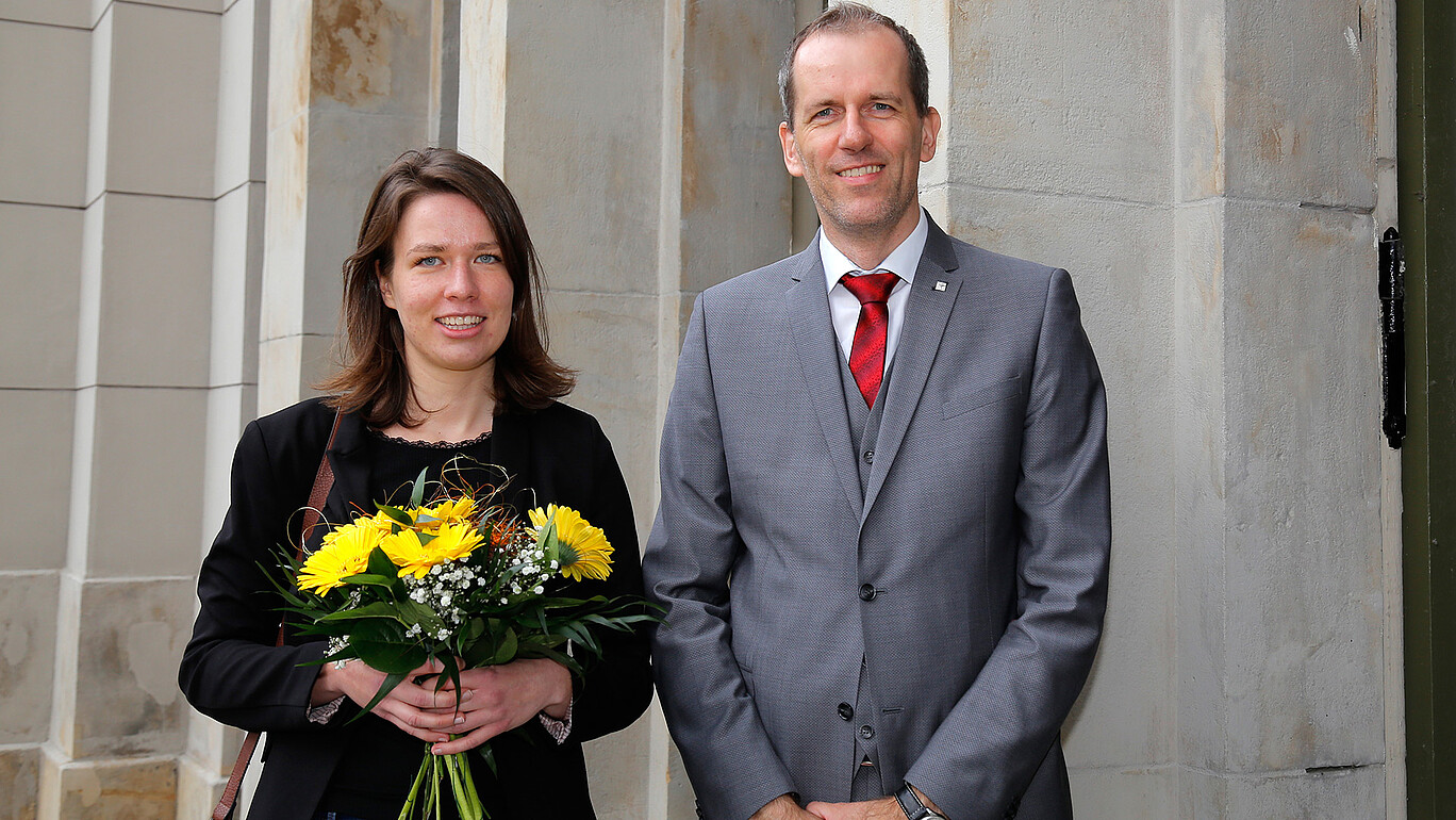 Frau mit Blumenstrauß und Mann im Anzug