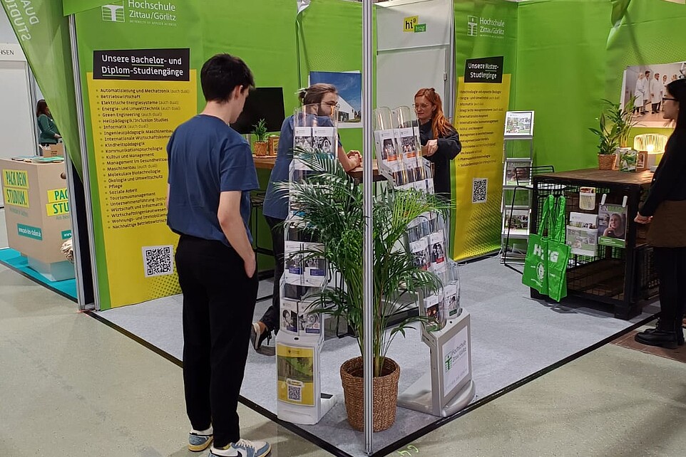 Messestand der HSZG mit Flyerständer im Vordergrund