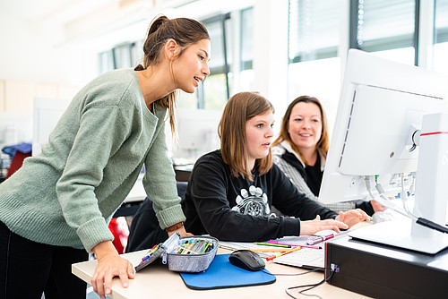 3 Studentinnen sitzen vor einem PC und arbeiten