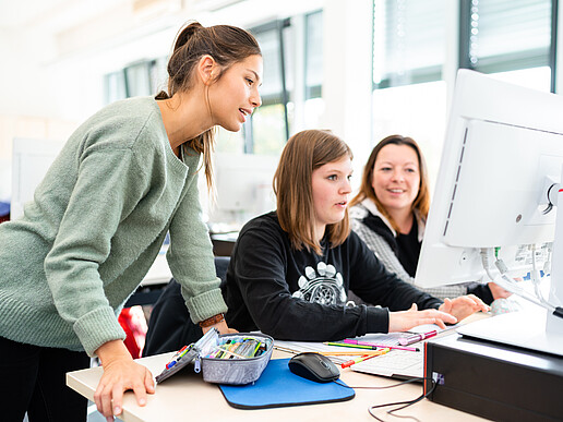 3 female students sit in front of a PC and work