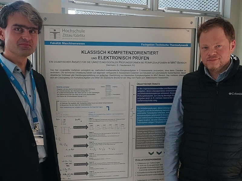 Dr.-Ing. Sebastian Herrmann (l., F-M) and Ronny Freudenreich, M.A. (ZWB) stand in front of a project poster.