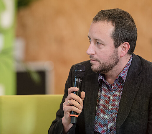 Representative of Studentenwerk Dresden with microphone on the talk sofa