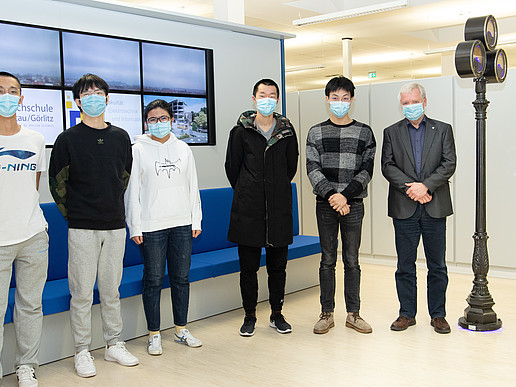 Four Chinese students and Professor Worlitz are standing in front of a row of benches in the laboratory.