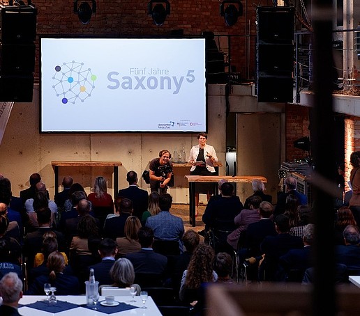 Ein Blick in das Pumpenhaus mit einer Leinwand im Hintergrund, auf der Saxony5 eingeblendet ist.