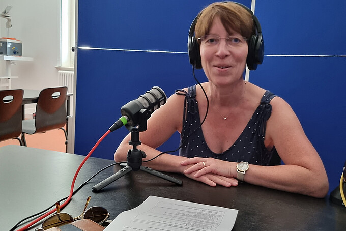 A podcast participant recording at the table.