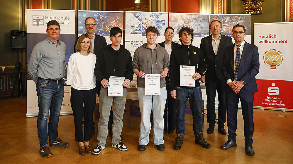 The winners and organizers of Neisse-Elektro stand next to each other for a group photo in the town hall of Zittau.