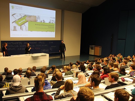 The advisors for foreign students introduce themselves in a lecture hall full of students.