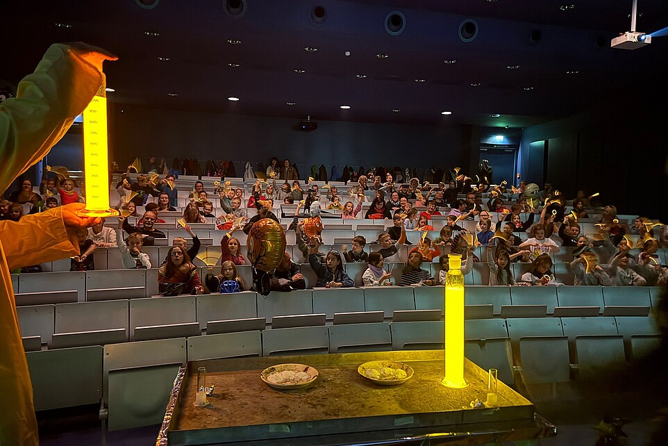 A lighting experiment with yellow neon paint takes place on stage.
