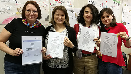 Vier Studentinnen aus St. Petersburg halten ihre TÜV-Zertifikate in der Hand